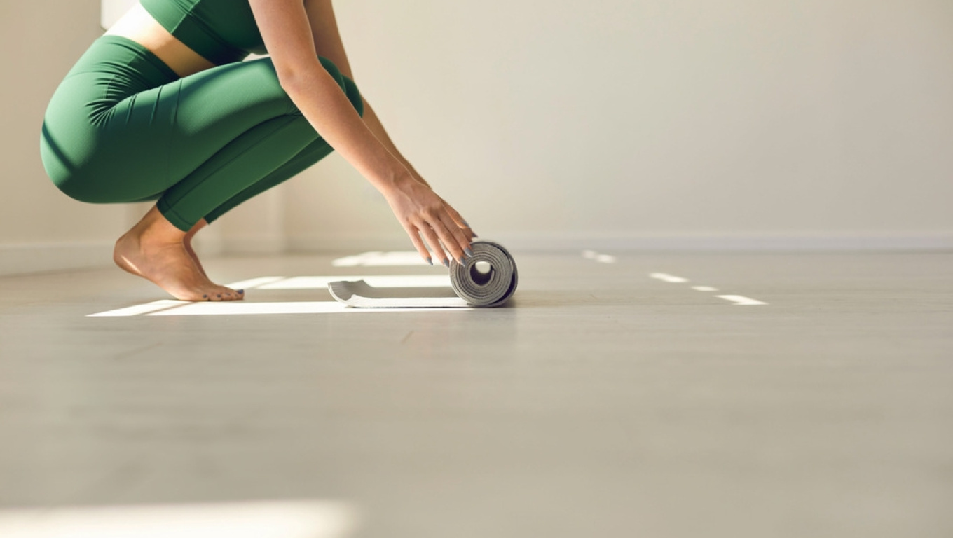Übung mit dem Pilatesring auf hellem Holzboden