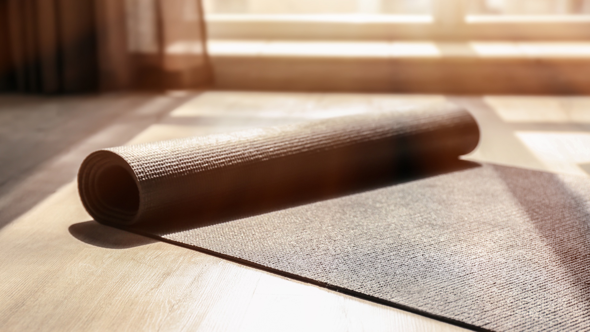 Teilweise aufgerollte Yogamatte im Sonnenlicht