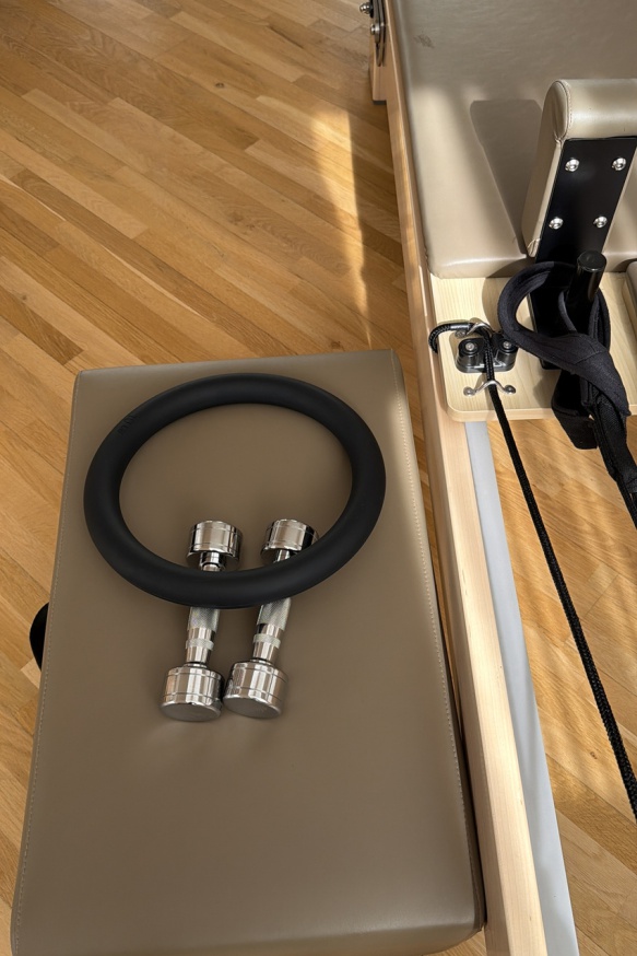 Pilatesring und Hanteln auf dem Reformer